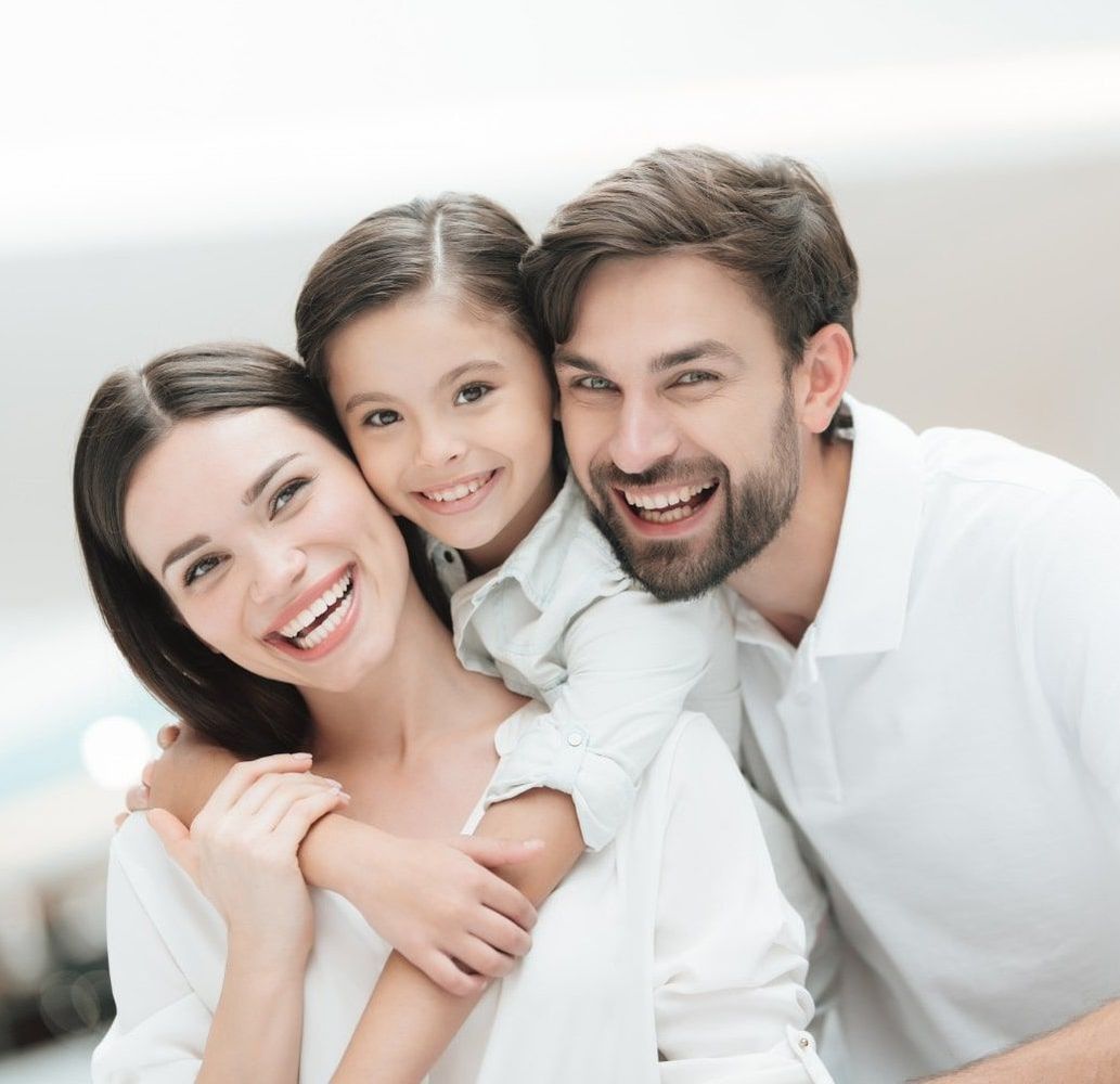 A man and woman are posing for a picture with their daughter.
