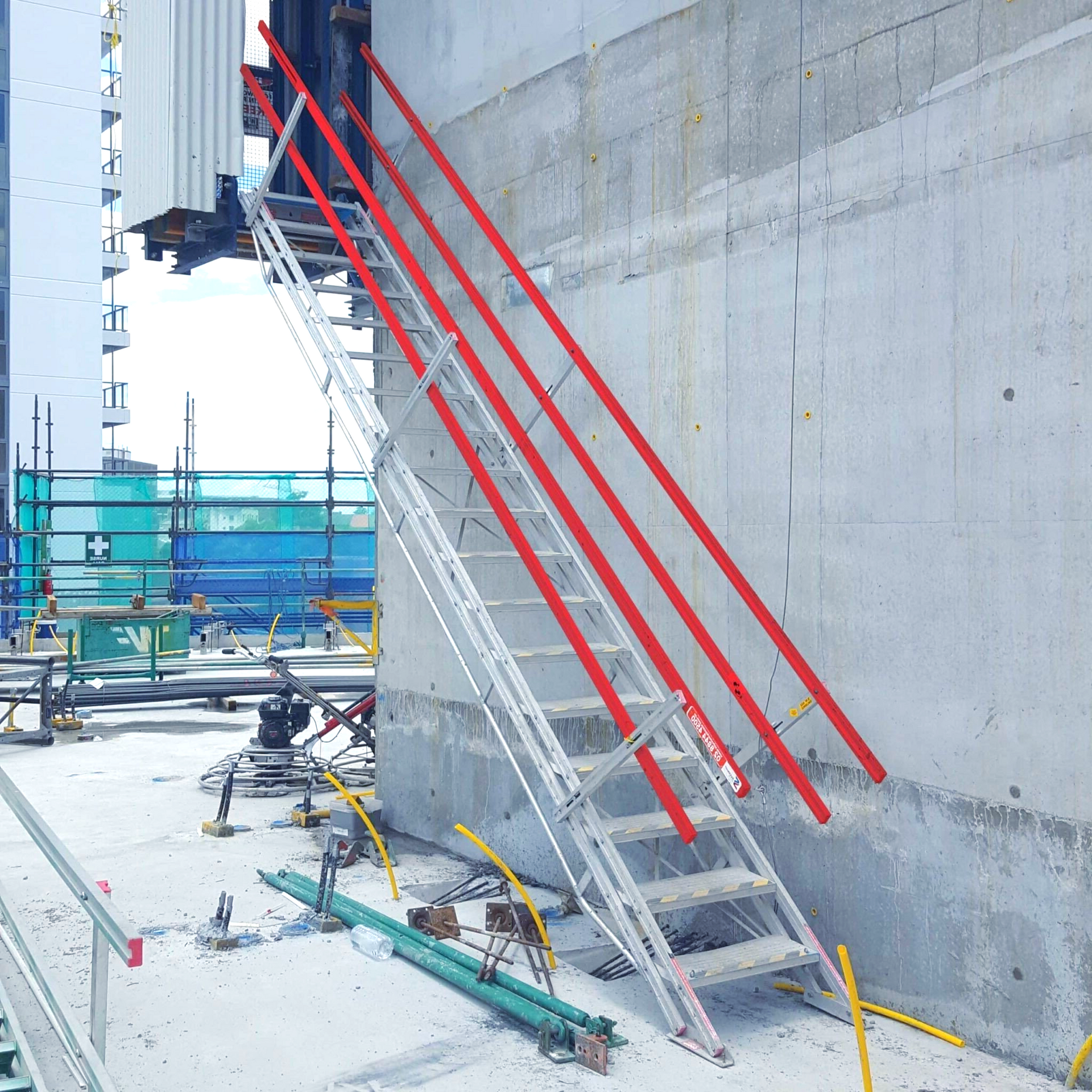 A metal ladder attached to a concrete wall. Red lines mark potential fall hazards. Construction site setting.