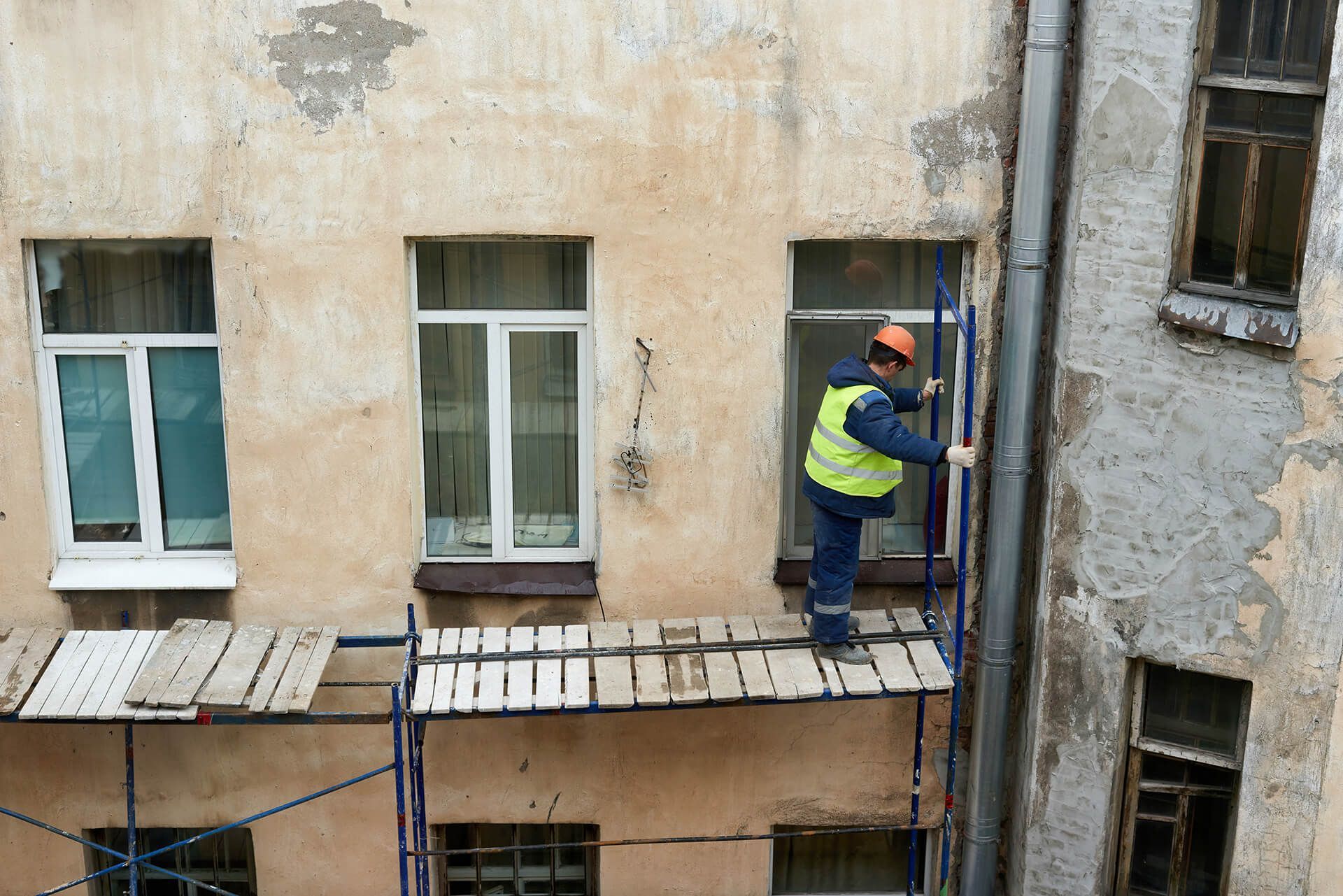 a man standing on a scaffold platform in front of a building