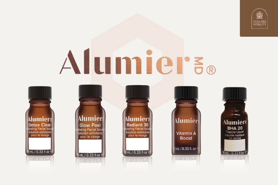 Five brown herbal supplement vials on a cream background with “AlumierMD” branding