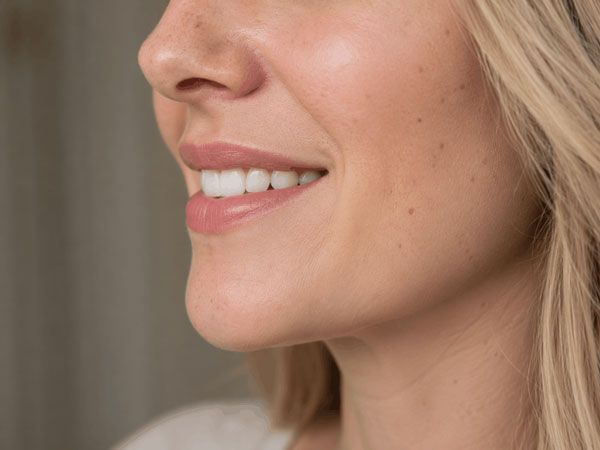 Close-up of a smiling face with natural makeup and blonde hair