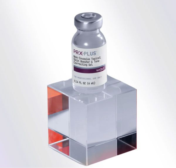 Small vial labeled “DRX Plus” on a clear acrylic cube stand against a white background