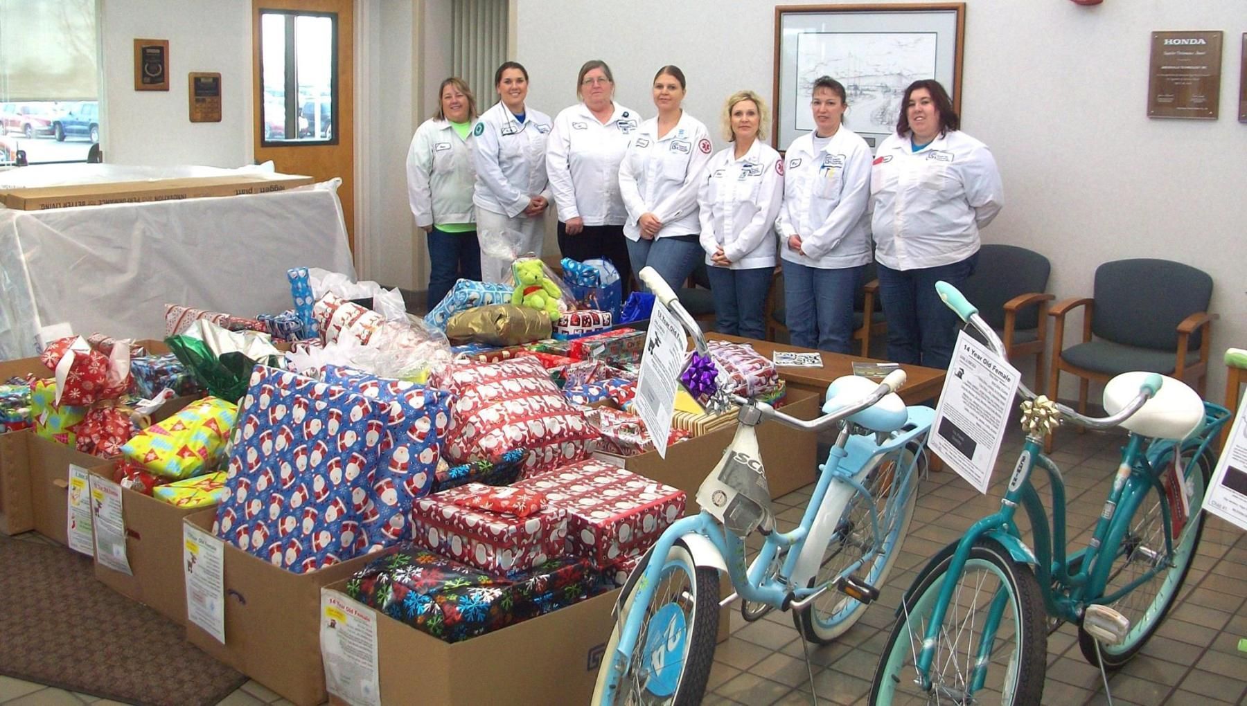 Group of people with gifts and bicycles indoors.