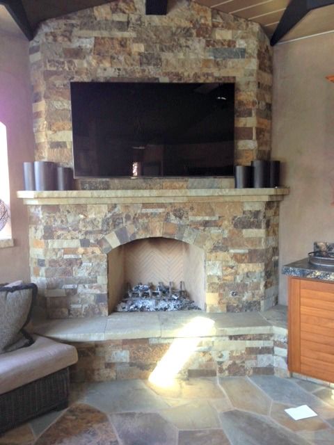 A stone fireplace with a flat screen tv above it