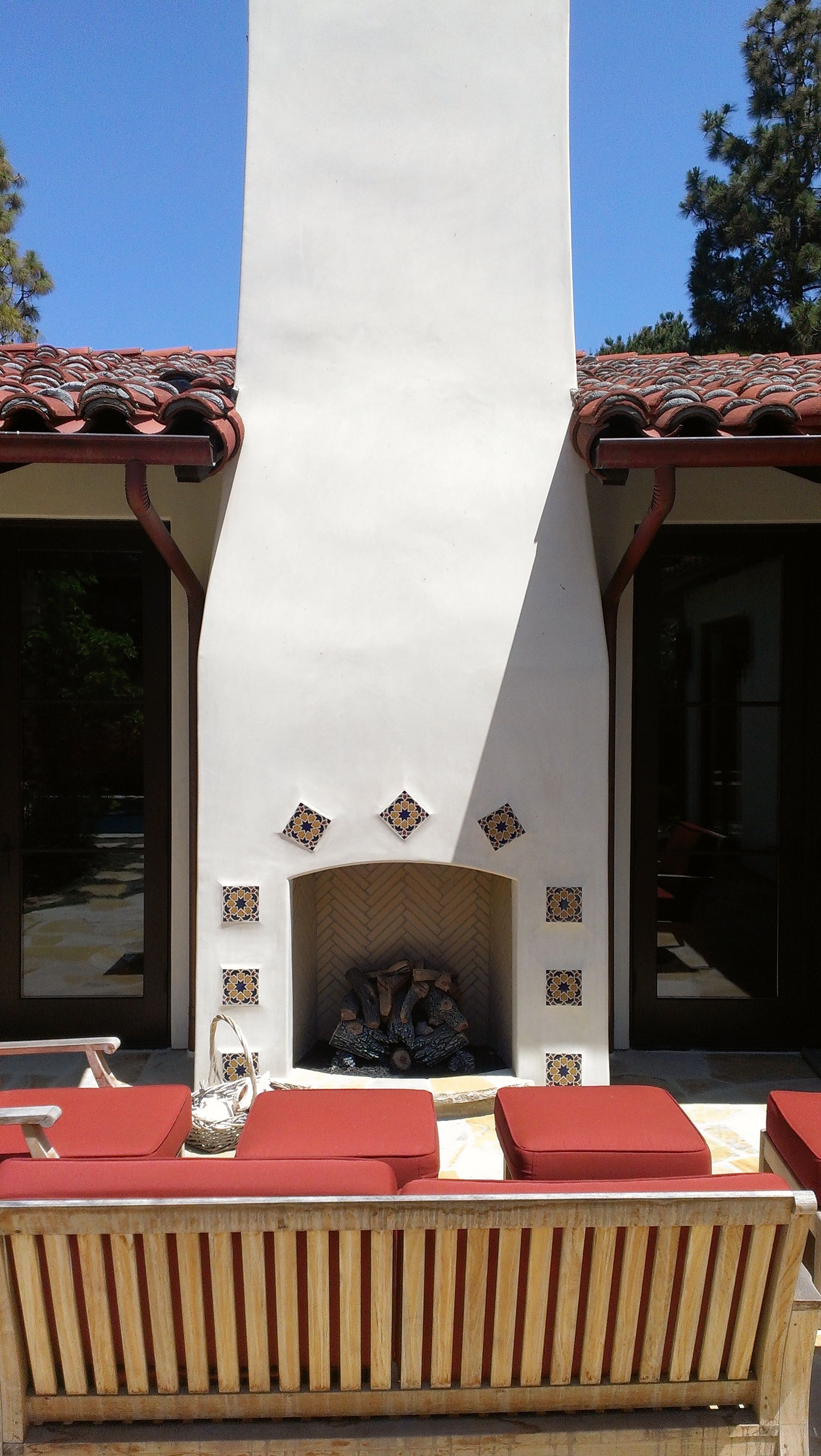 A white fireplace with a wooden bench in front of it