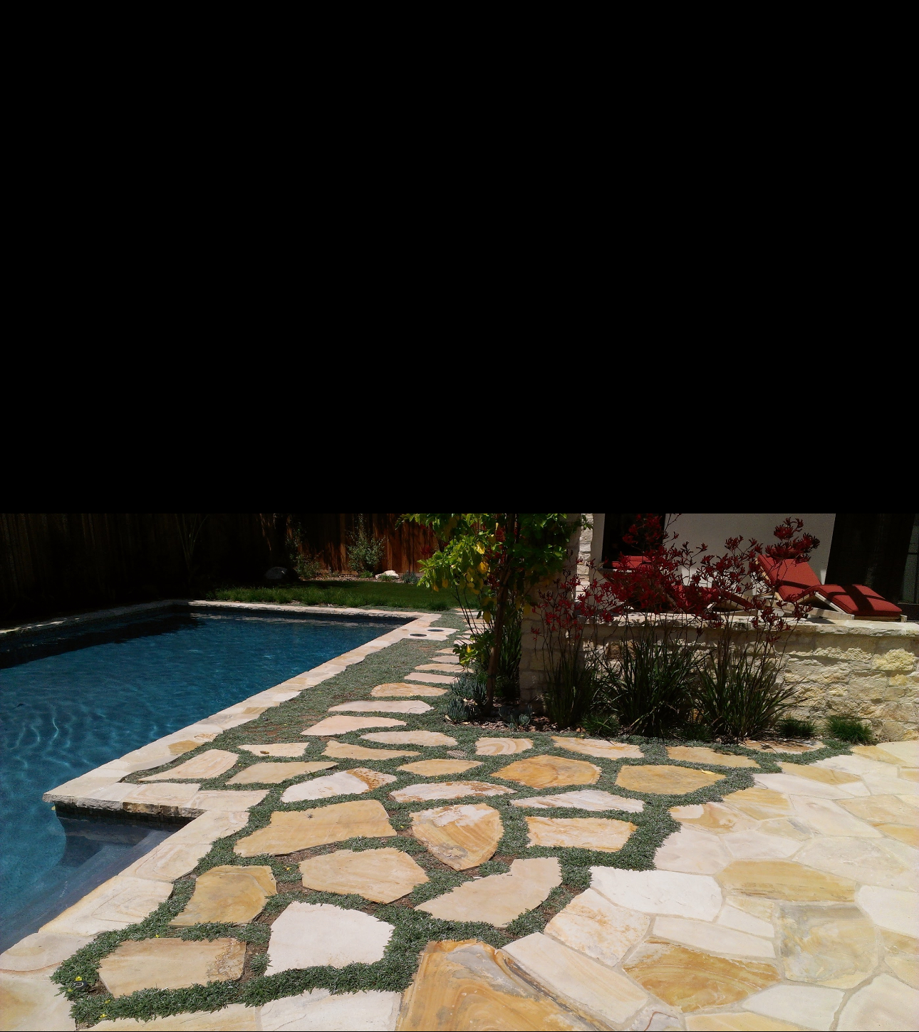 A swimming pool with a stone walkway leading to it