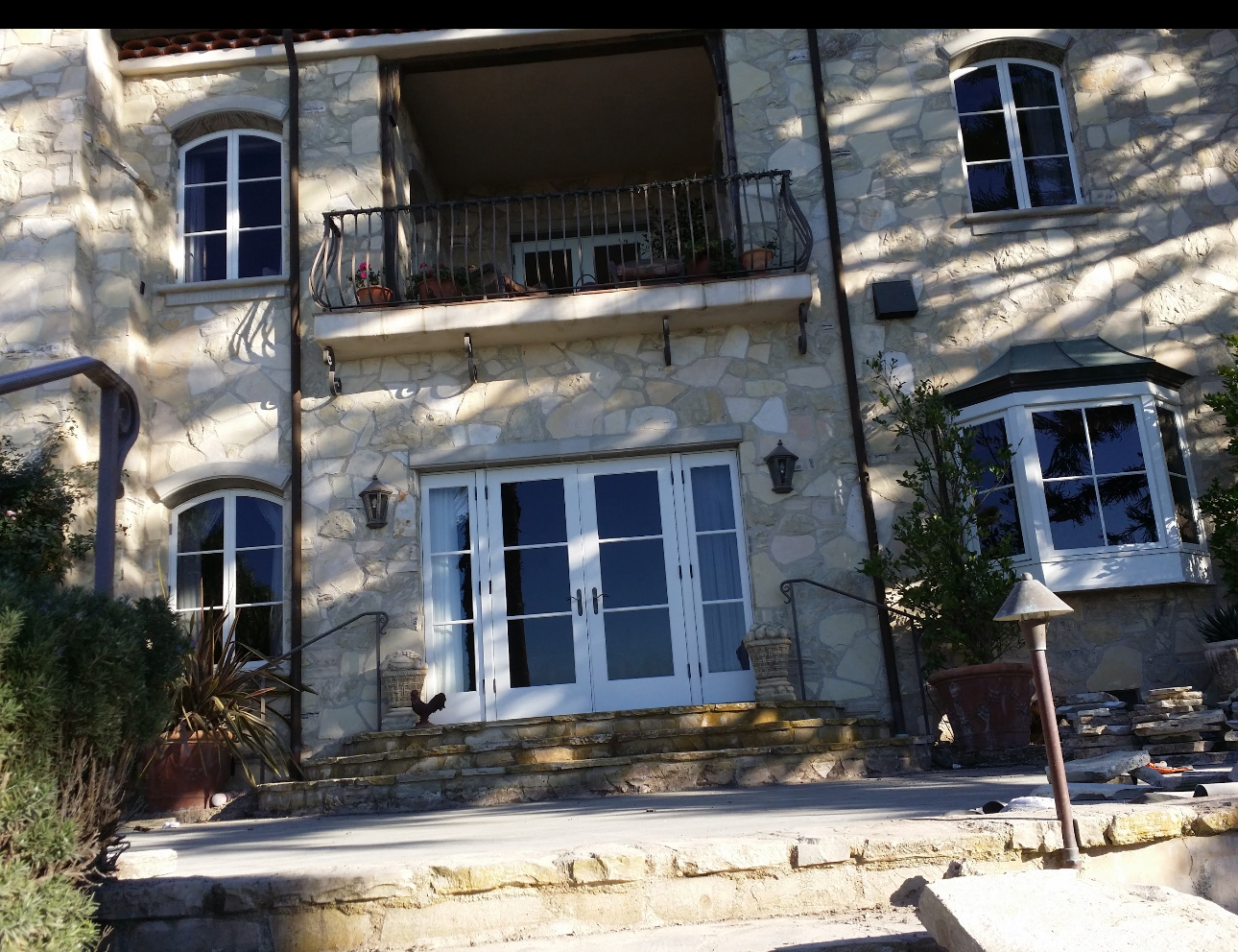 A large stone house with a balcony and stairs