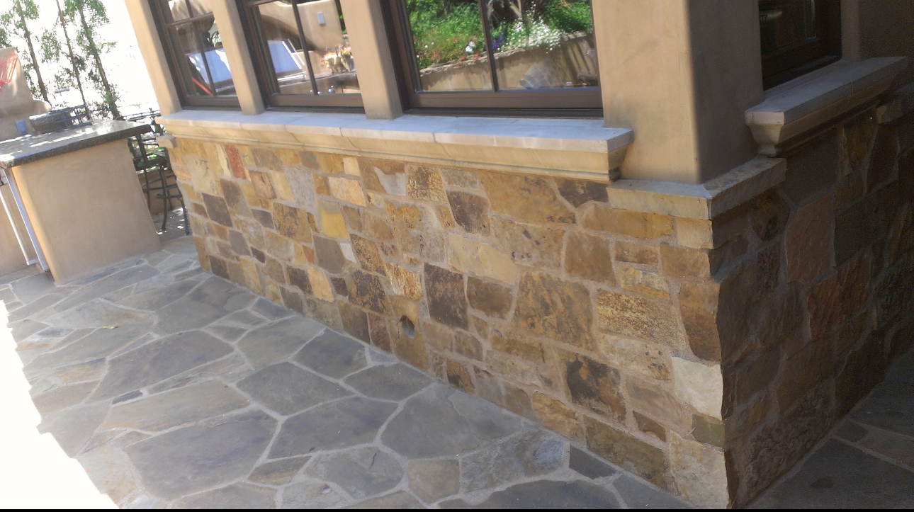 A stone wall with a window on the side of it