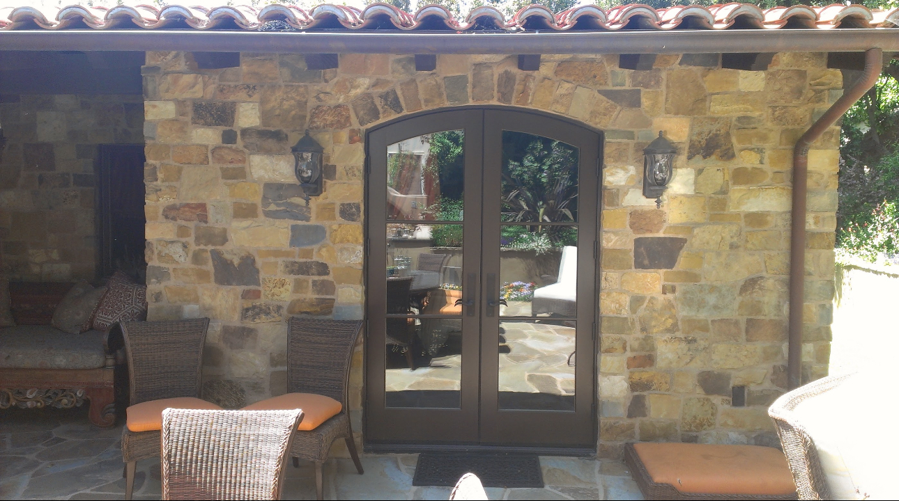 A stone building with a patio and chairs in front of it
