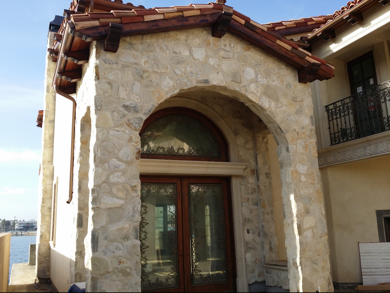 A stone building with a wooden door and a balcony