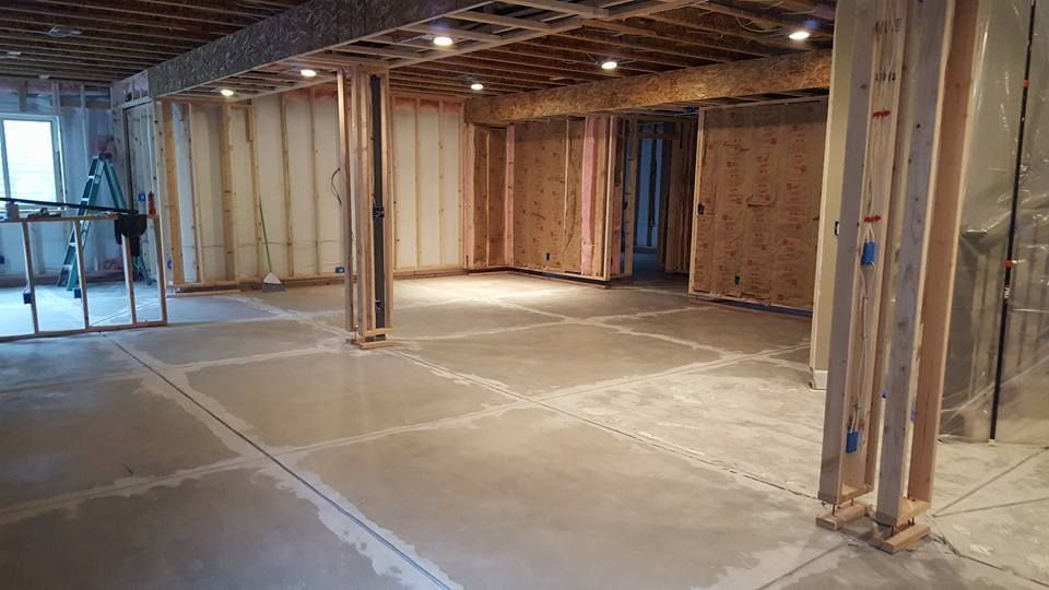 Unfinished basement with wooden framing, concrete floor, and recessed lighting.