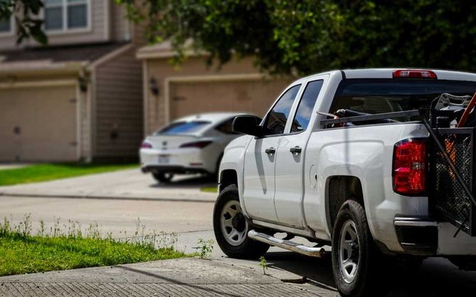 A white pickup truck in a suburb of thunder bay with junk in the truck bed