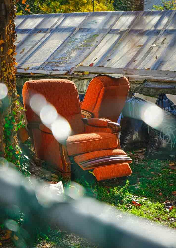 old red lazy boy chair ready to be picked up outside by a junk removal company