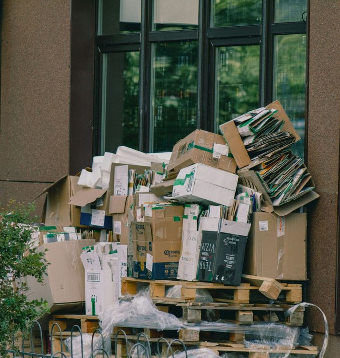 Pile of cardboard boxes and paper trash stacked outside a building entrance in downtown Port Arthur