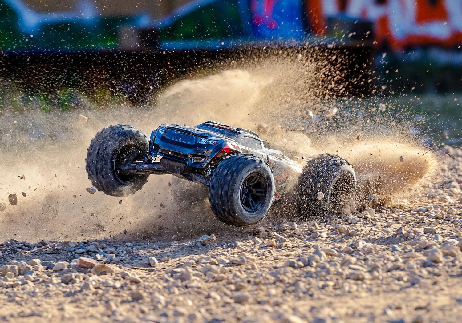 Een RC-truck die stof en vuil opwerpt op een grindoppervlak.