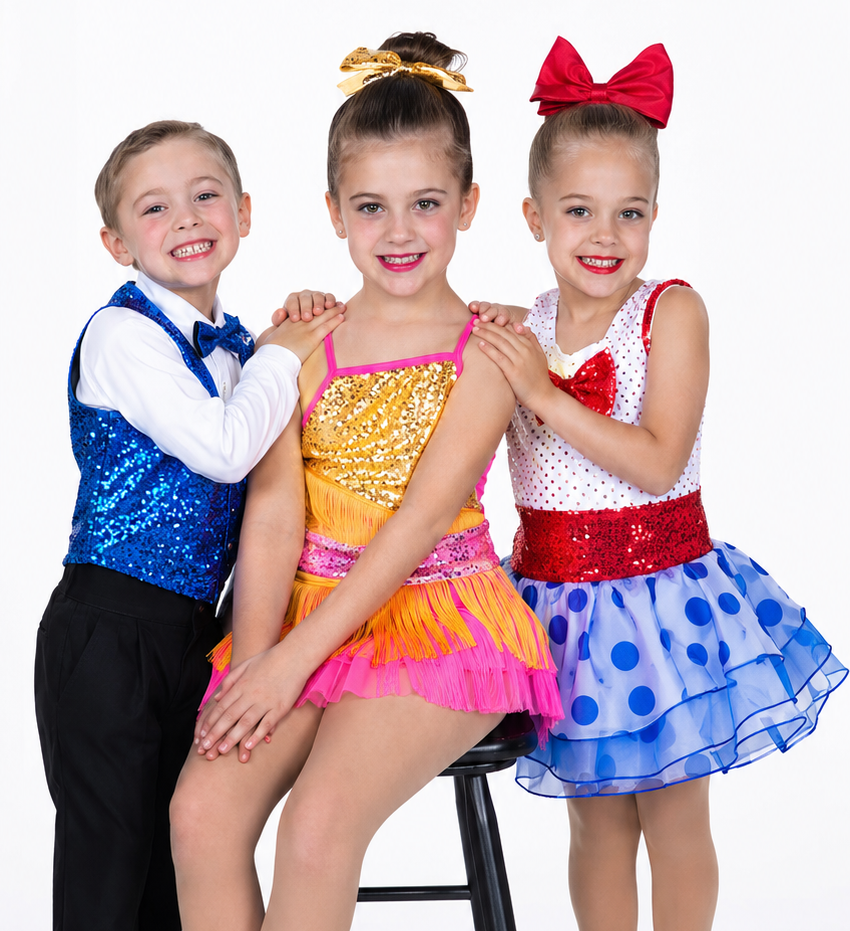 Three children in colorful dance costumes posing together on a stool, smiling against a white background.