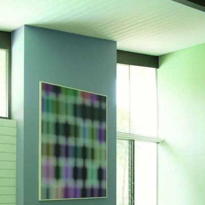 Abstract geometric painting on a teal wall in a bright, modern room