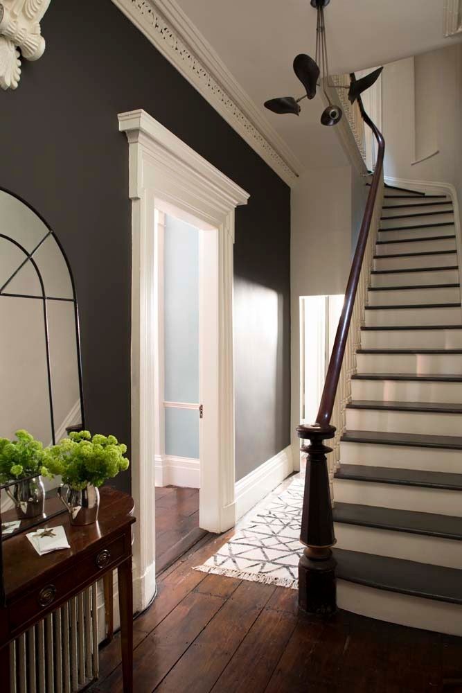 Bright entry hall with dark walls, white trim, staircase, and hardwood floor.