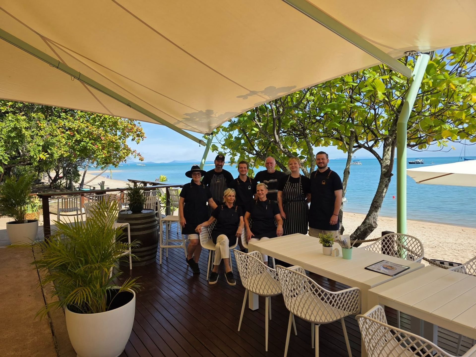 Group of People Standing Under a Beachside Cafe Canopy — The Beach Bar and Restaurant at Montes in Cape Gloucester, QLD