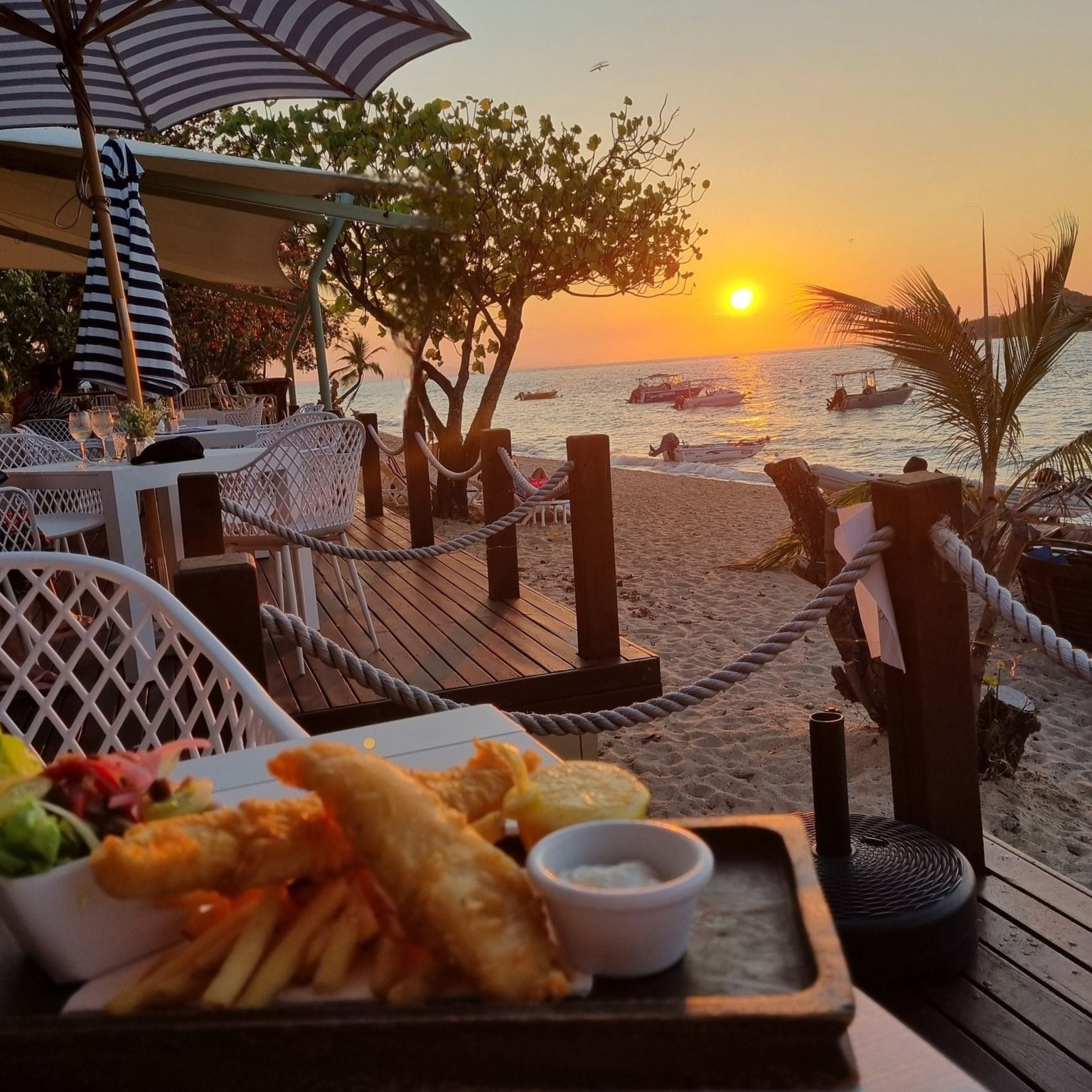 Person Smiling and Eating a Burger at an Outdoor Restaurant — The Beach Bar and Restaurant at Montes in Cape Gloucester, QLD