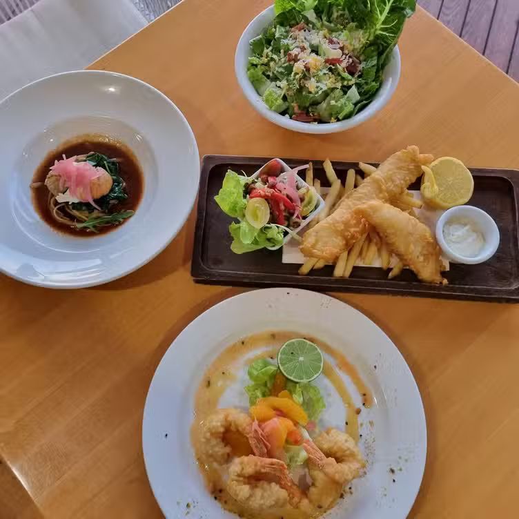 Overhead view of a wooden table set with several dishes — The Beach Bar and Restaurant at Montes in Cape Gloucester, QLD
