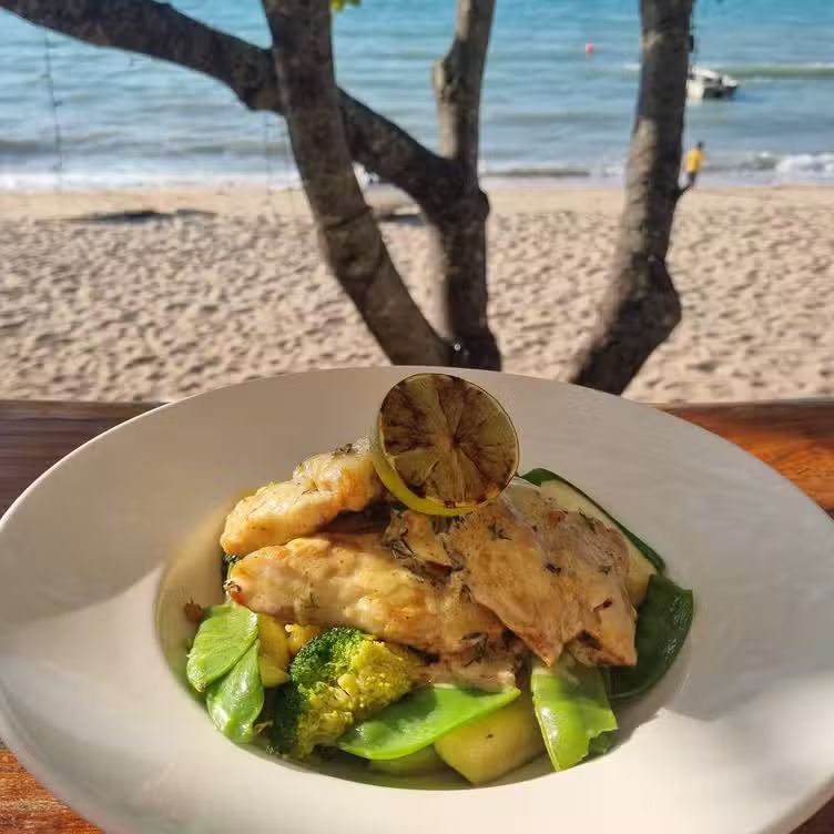 Grilled fish with vegetables and a lemon wedge — The Beach Bar and Restaurant at Montes in Cape Gloucester, QLD