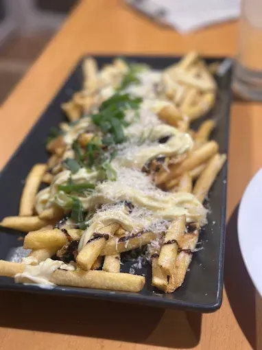 Fries with white sauce, grated cheese and green garnish — The Beach Bar and Restaurant at Montes in Cape Gloucester, QLD
