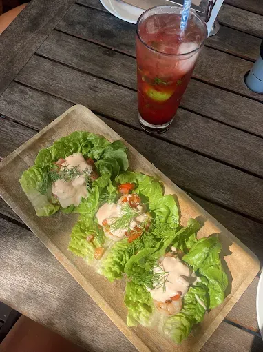 Lettuce wraps on wooden tray with pink sauce — The Beach Bar and Restaurant at Montes in Cape Gloucester, QLD