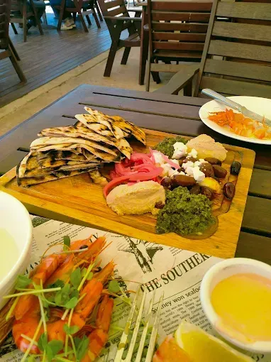 A wooden board with Middle Eastern food — The Beach Bar and Restaurant at Montes in Cape Gloucester, QLD