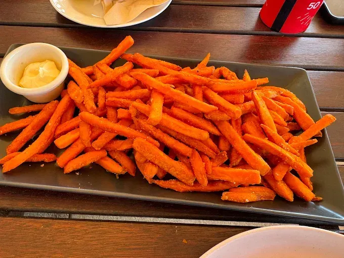 Sweet potato fries with dipping sauce on a rectangular plate — The Beach Bar and Restaurant at Montes in Cape Gloucester, QLD