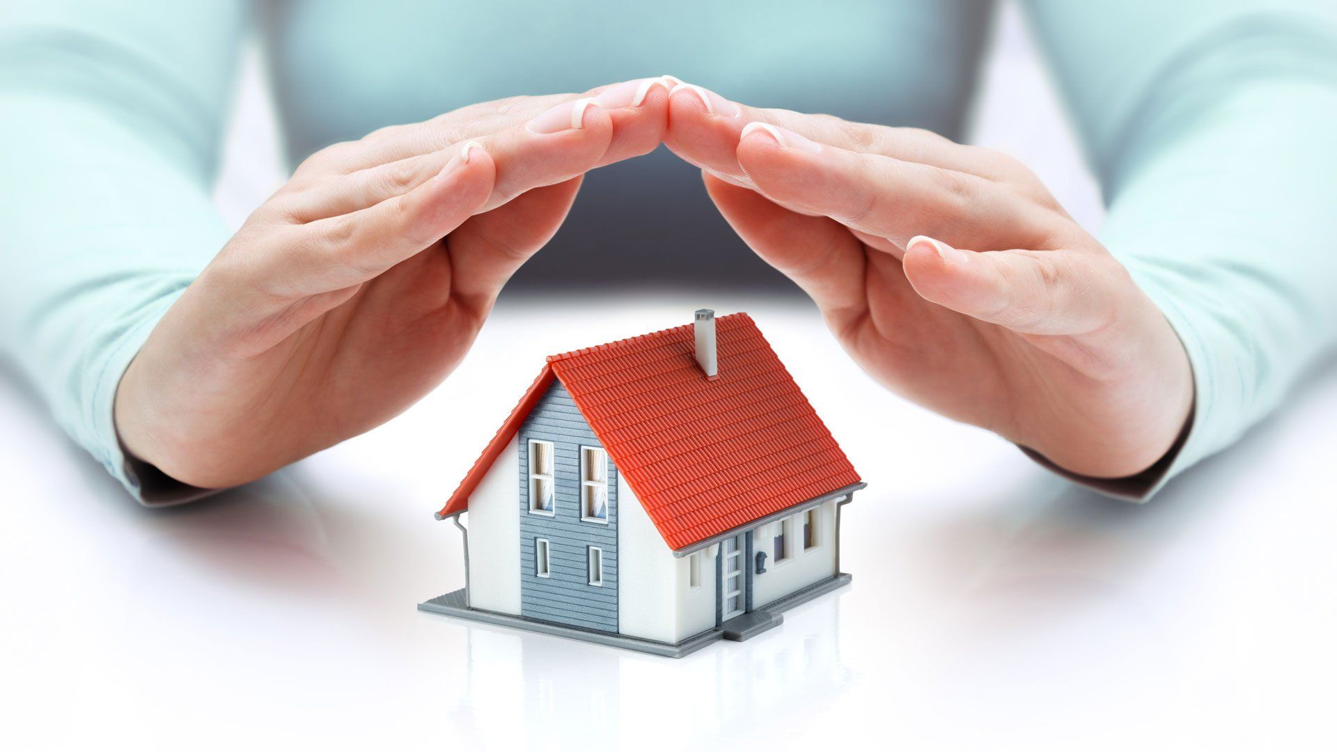 Hand Covering Miniature House — Raymore, MO — Stan Ruby Insurance Agency