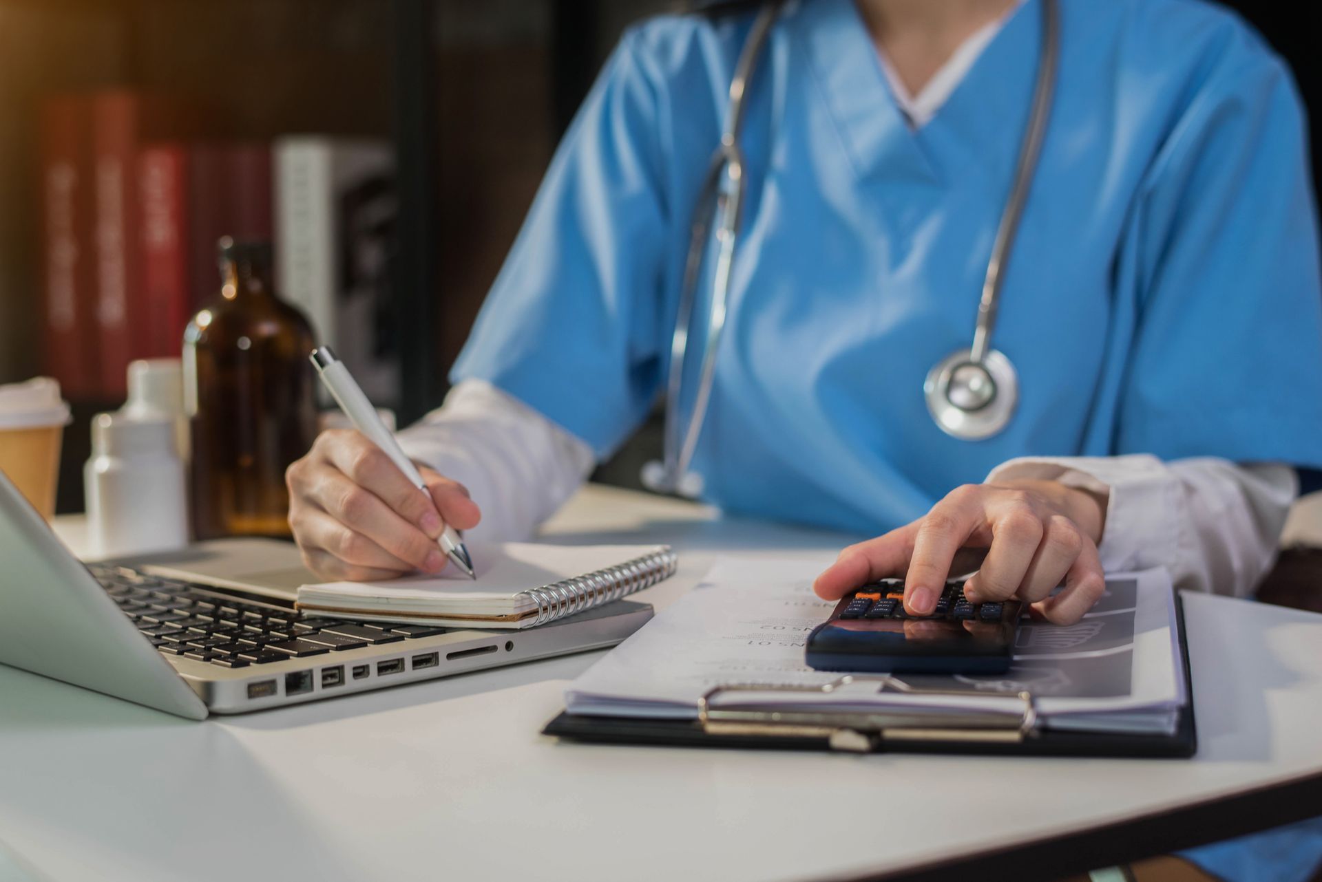 Working on desk with calculate medical fee costs & revenue