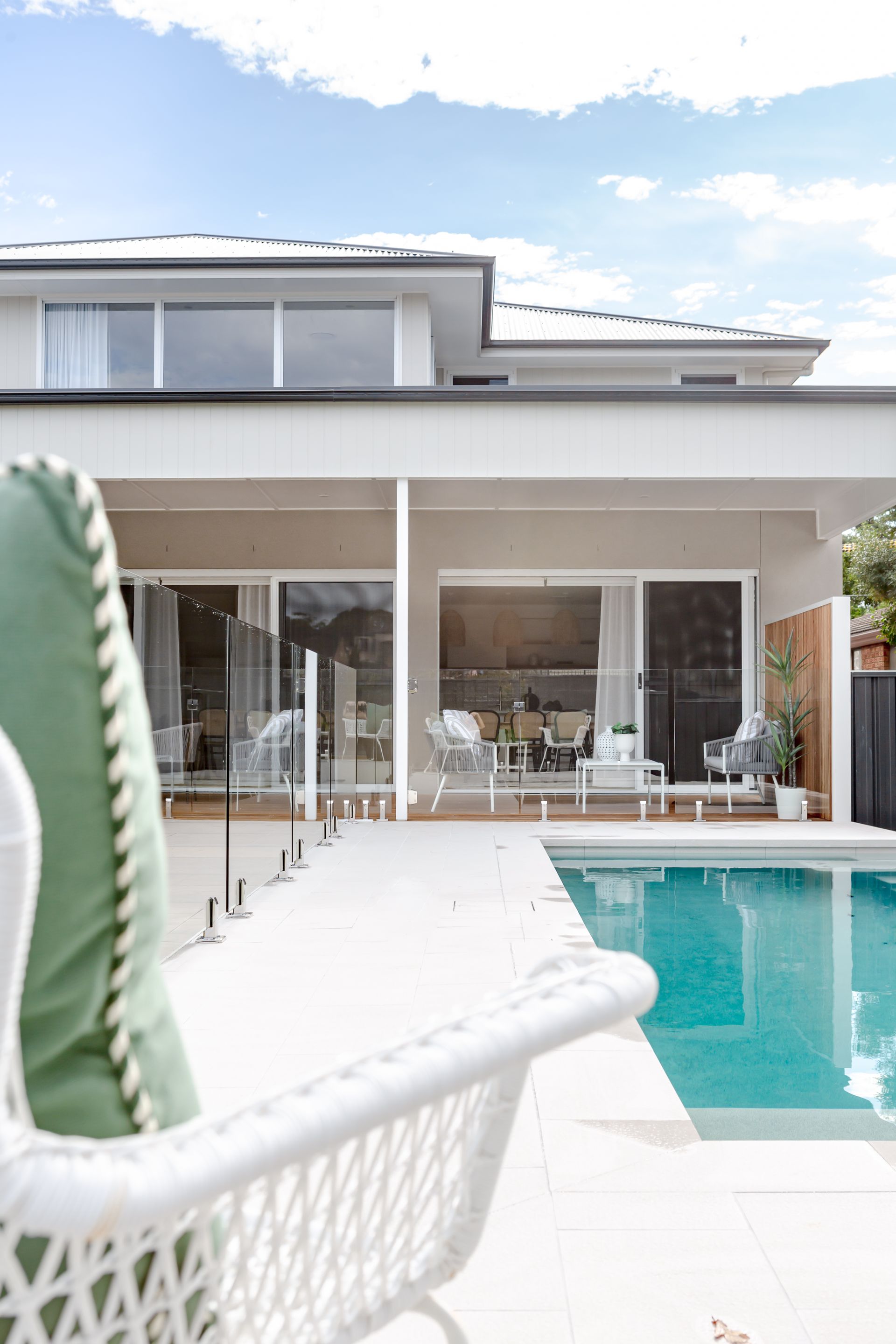 White modern house with pool and lounge chair.