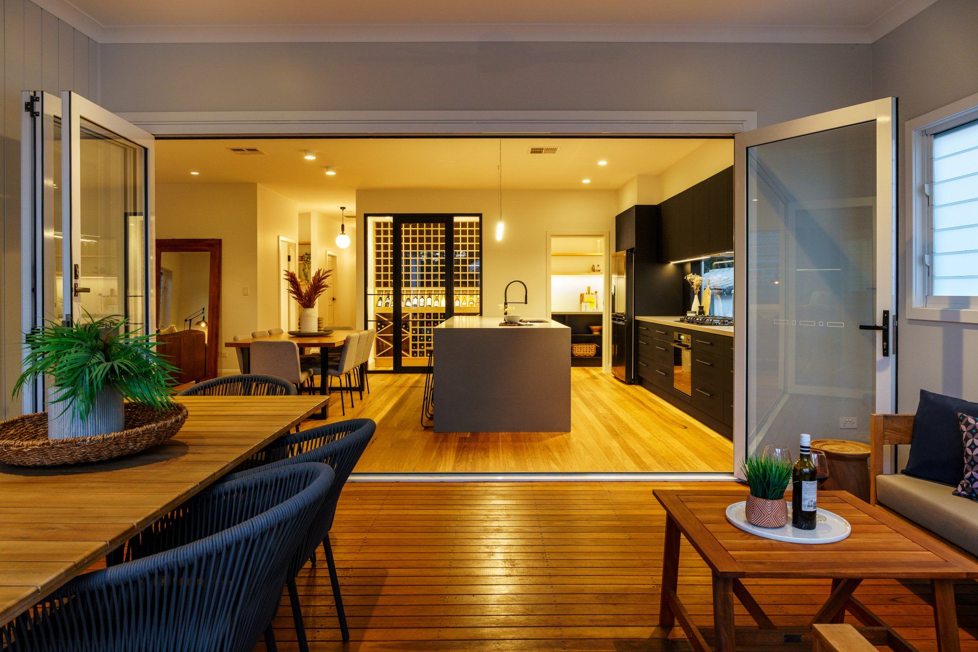 Open doors reveal a kitchen and dining area with wood floors and dark cabinets.