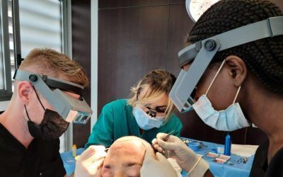 A group of dentists are working on a patient 's face.