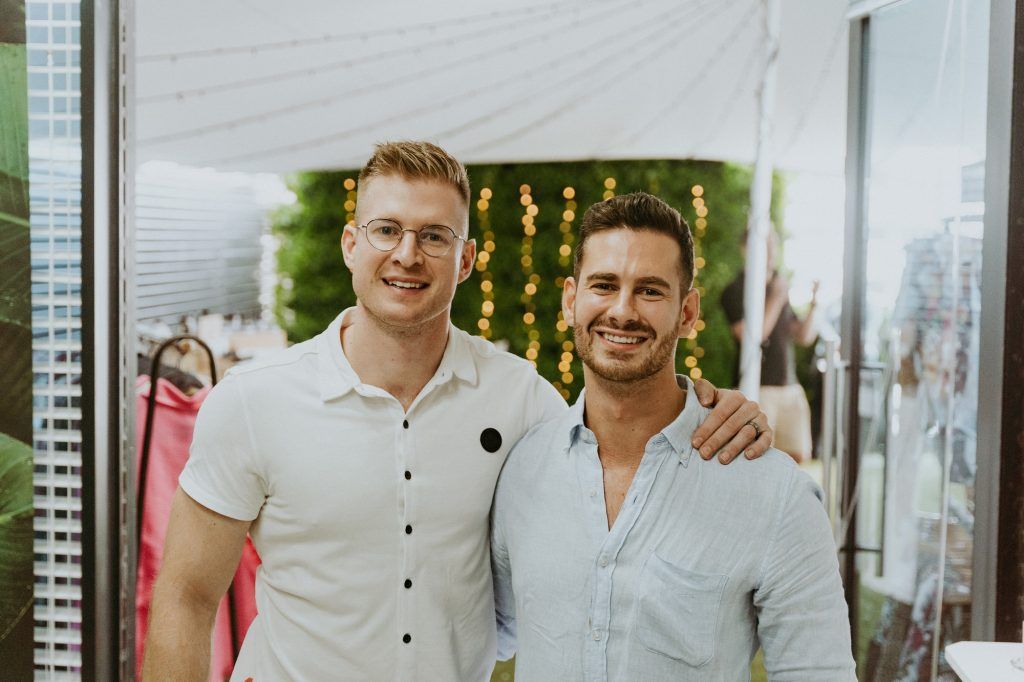 Two men are standing next to each other and posing for a picture.