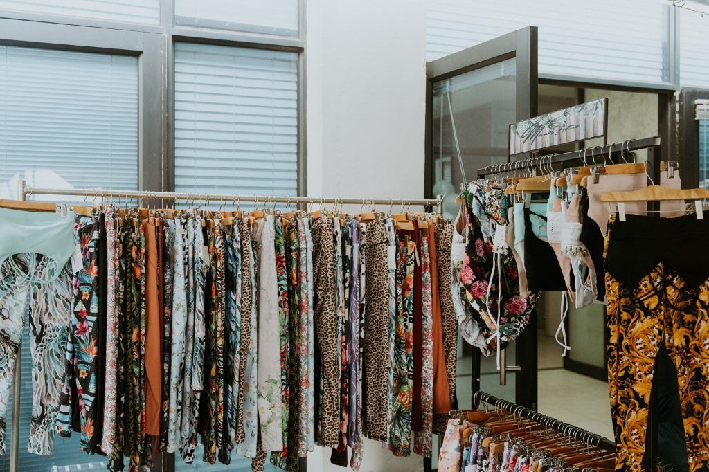 A bunch of clothes are hanging on a rack in a store.