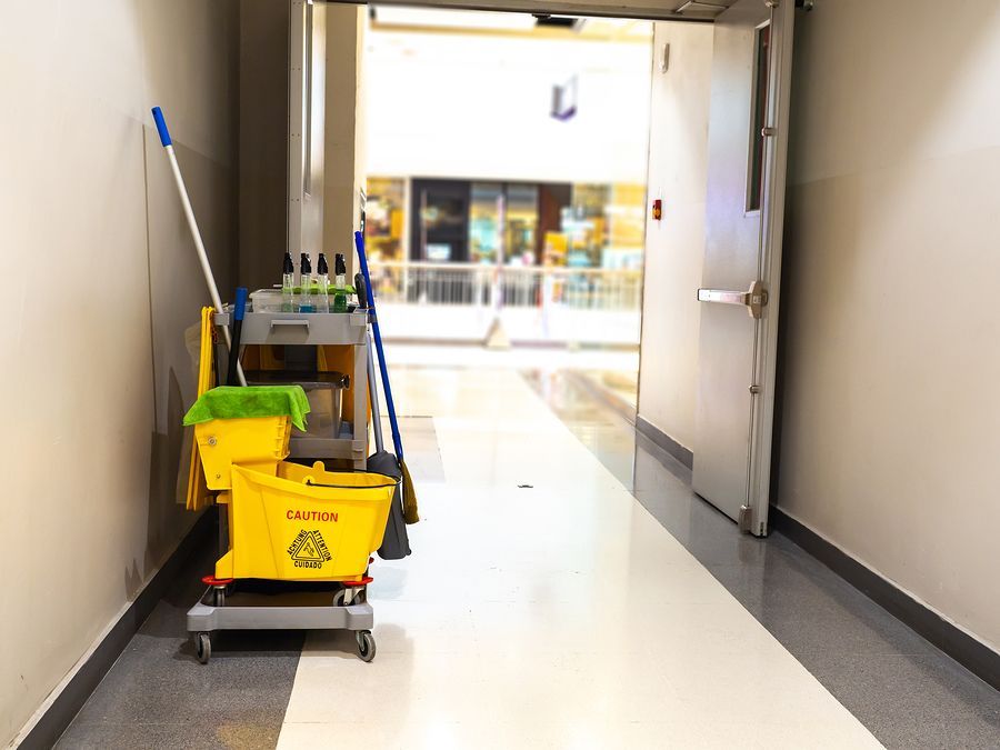 a hallway with a mop and buckets of cleaning supplies