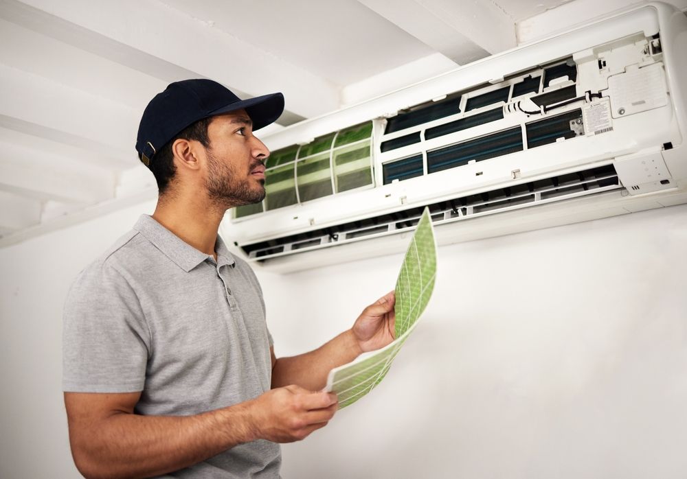 A technician inspecting an air conditioner as part of office cleaning methods in Sydney.