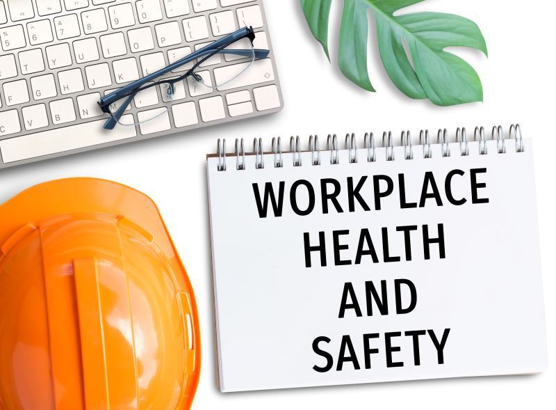 Office cleaning standards concept with workplace safety notebook, hard hat, and cleaning items