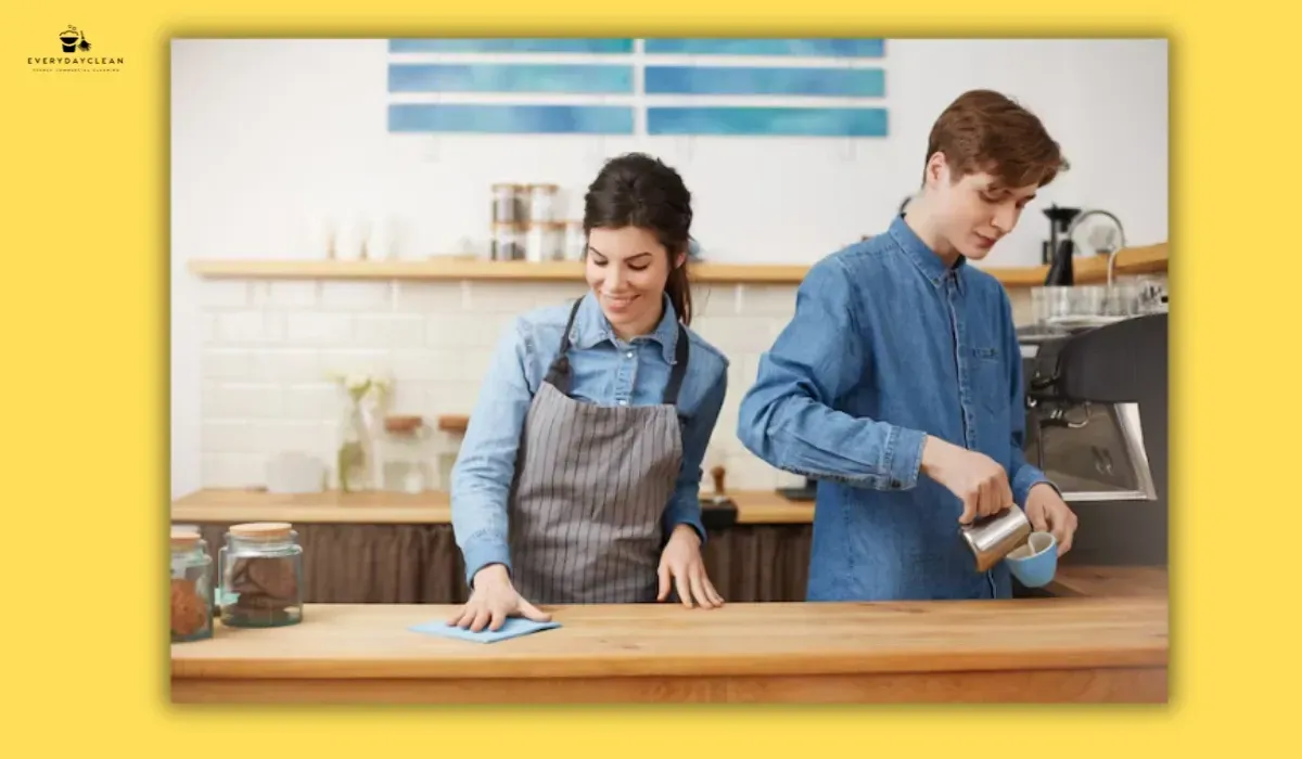 Office staff and professional cleaners sharing office kitchen cleaning responsibilities
