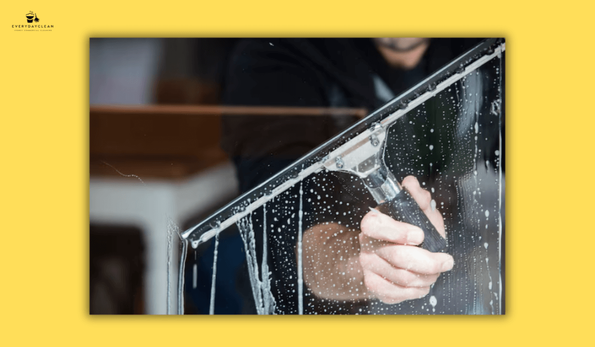 person scrubbing stained window glass
