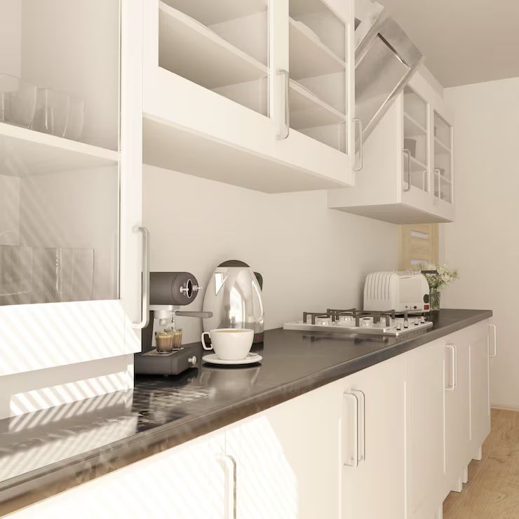 White kitchen with upper cabinets, countertop with appliances, and a cup.