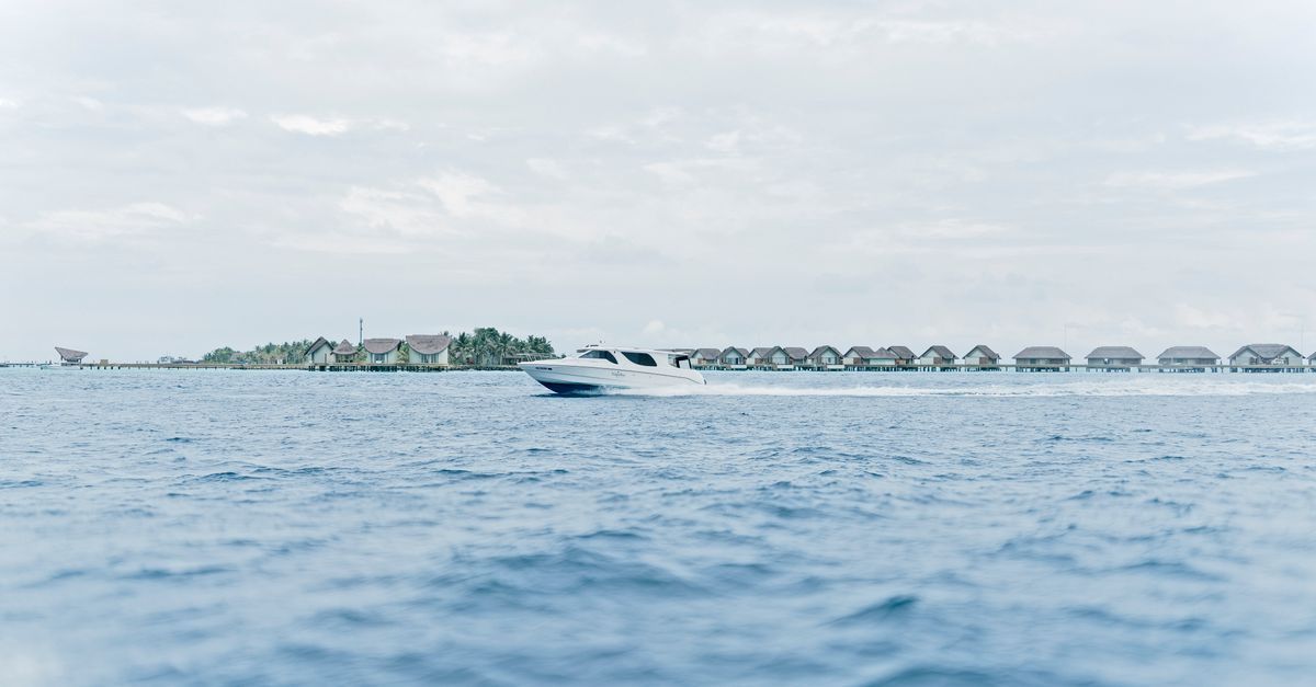 Speedboat travelling between two Maldives resort islands across a turquoise lagoon