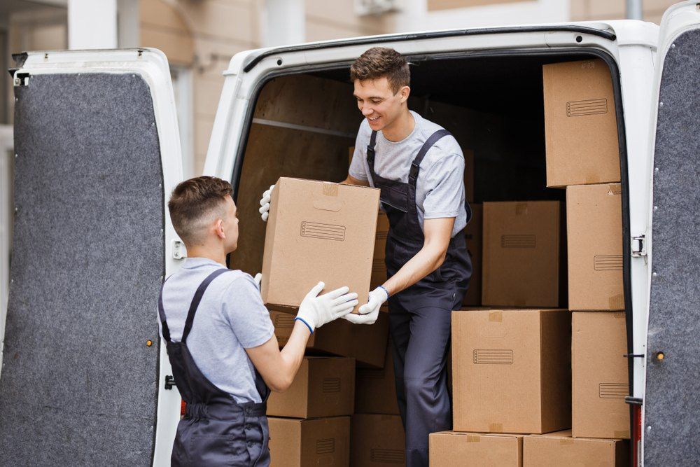 Two Men Are Loading Boxes Into a Van — Buck Removals & Storage in Griffith, NSW