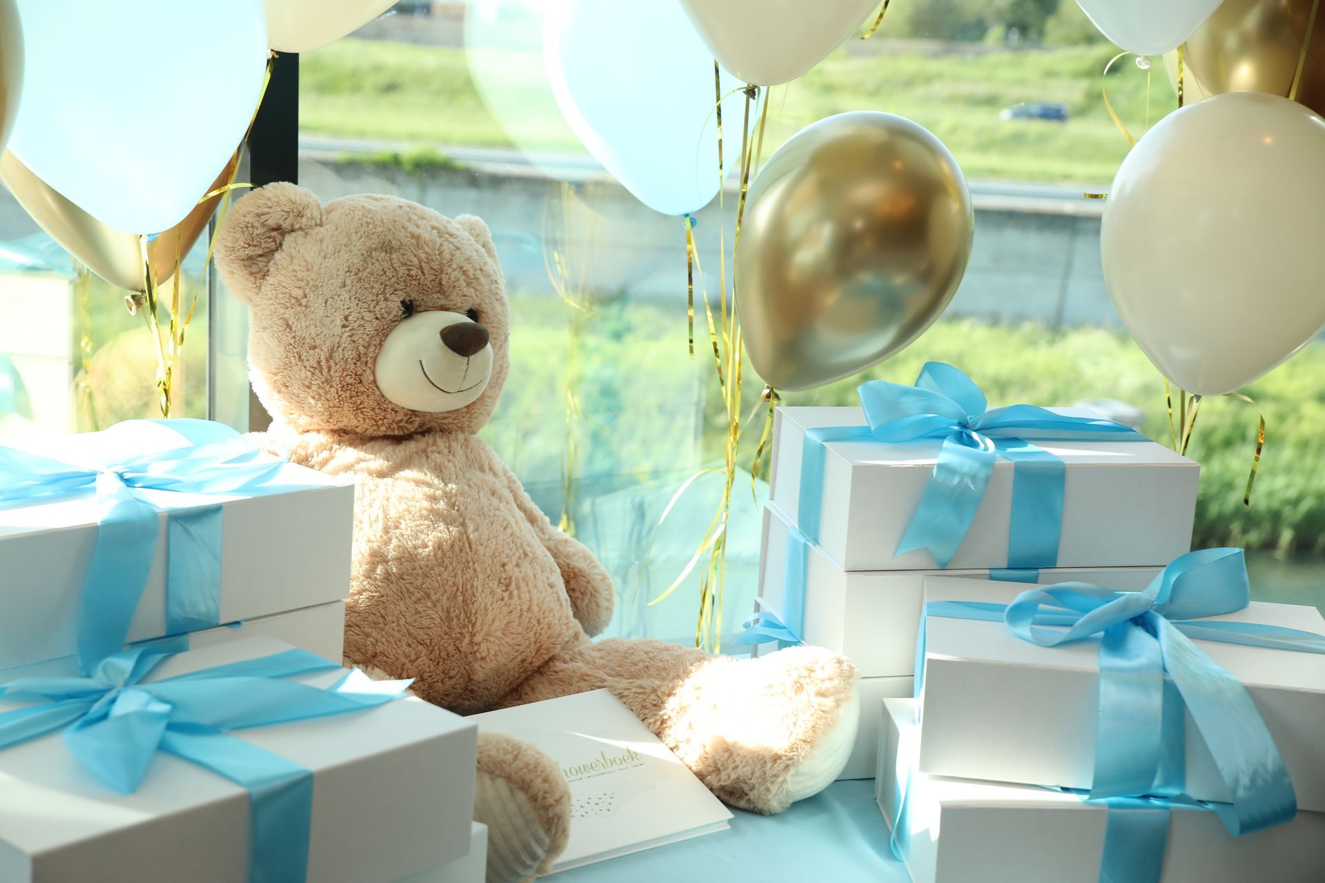 Een teddybeer omringd door cadeautjes met blauwe linten en ballonnen; een verjaardagsfeestsetting.