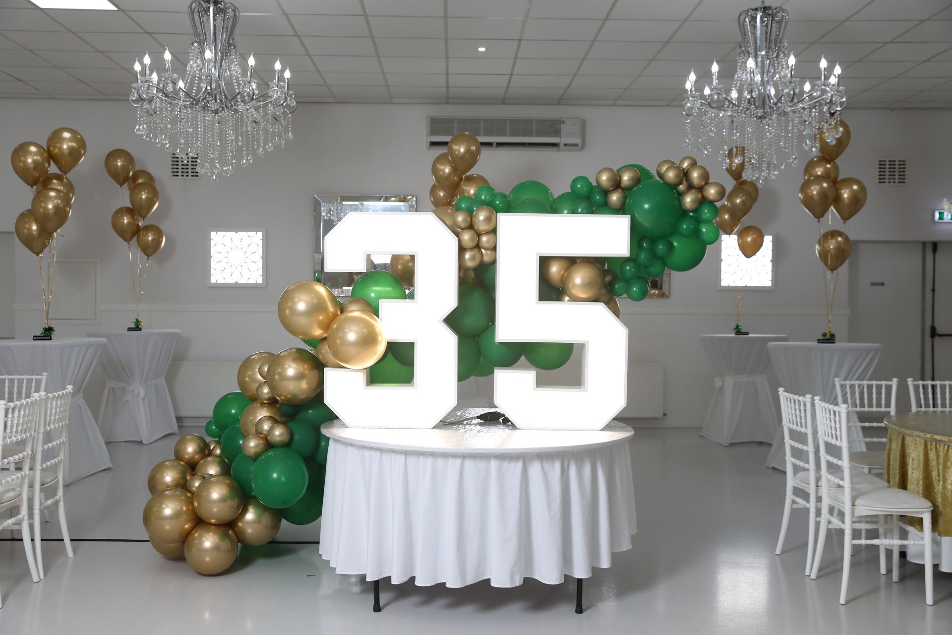De feestzaal voor het verjaardagsfeest was versierd met gouden en groene ballonnen, een verlicht 