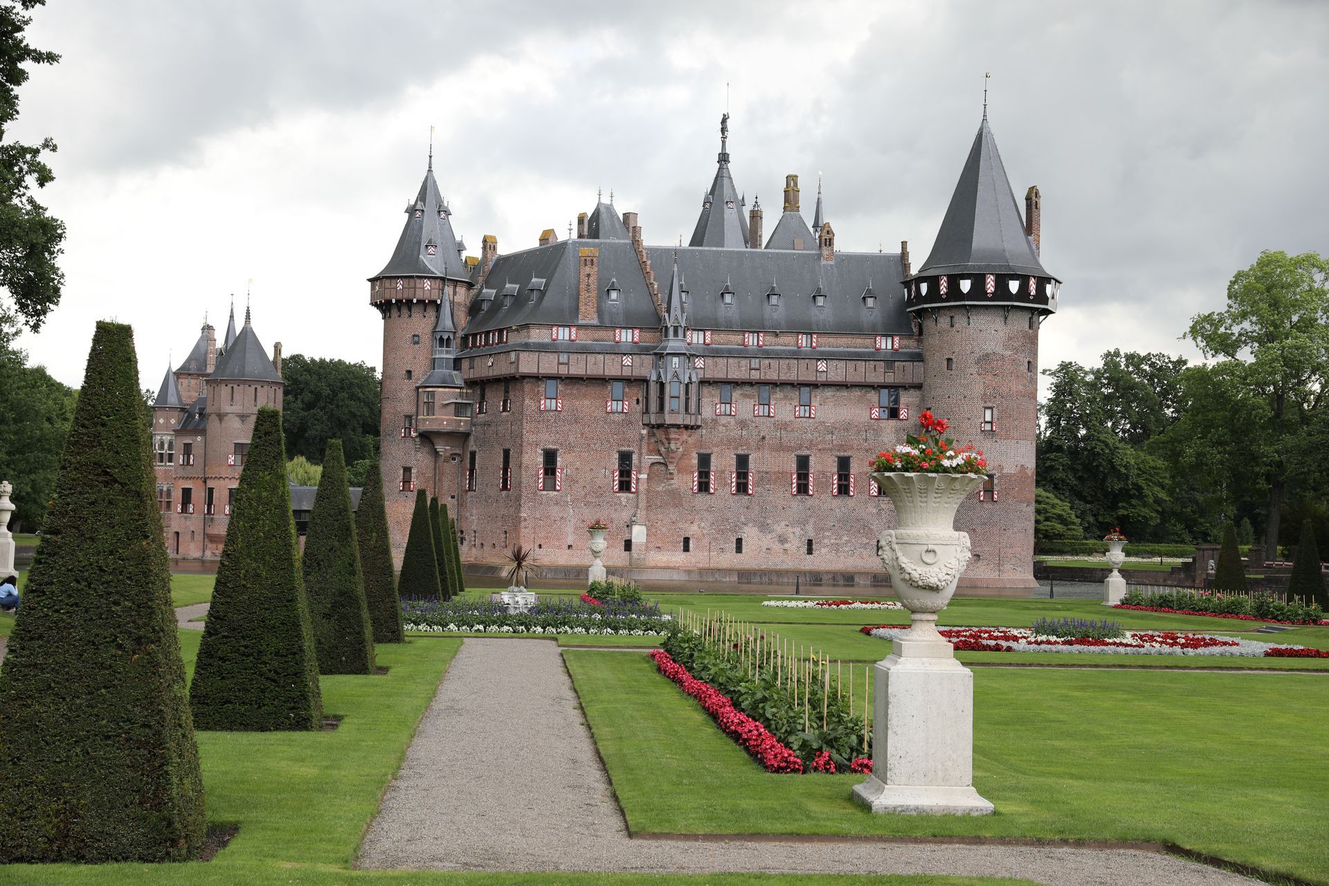 Kasteel De Haar, Nederland, met verzorgde tuinen en symmetrisch gesnoeide bomen.