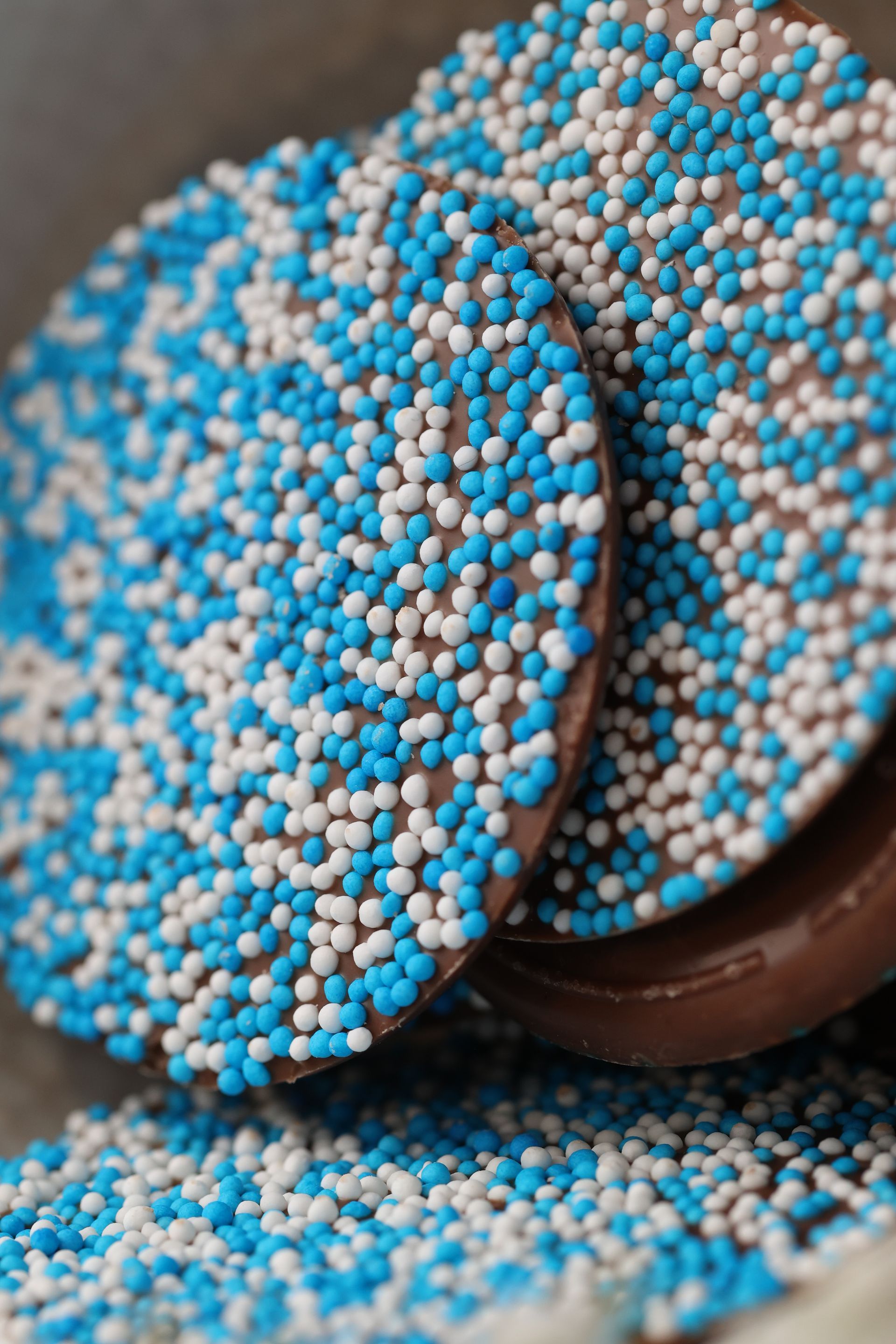 Chocoladeschijfjes bedekt met blauwe en witte hagelslag.