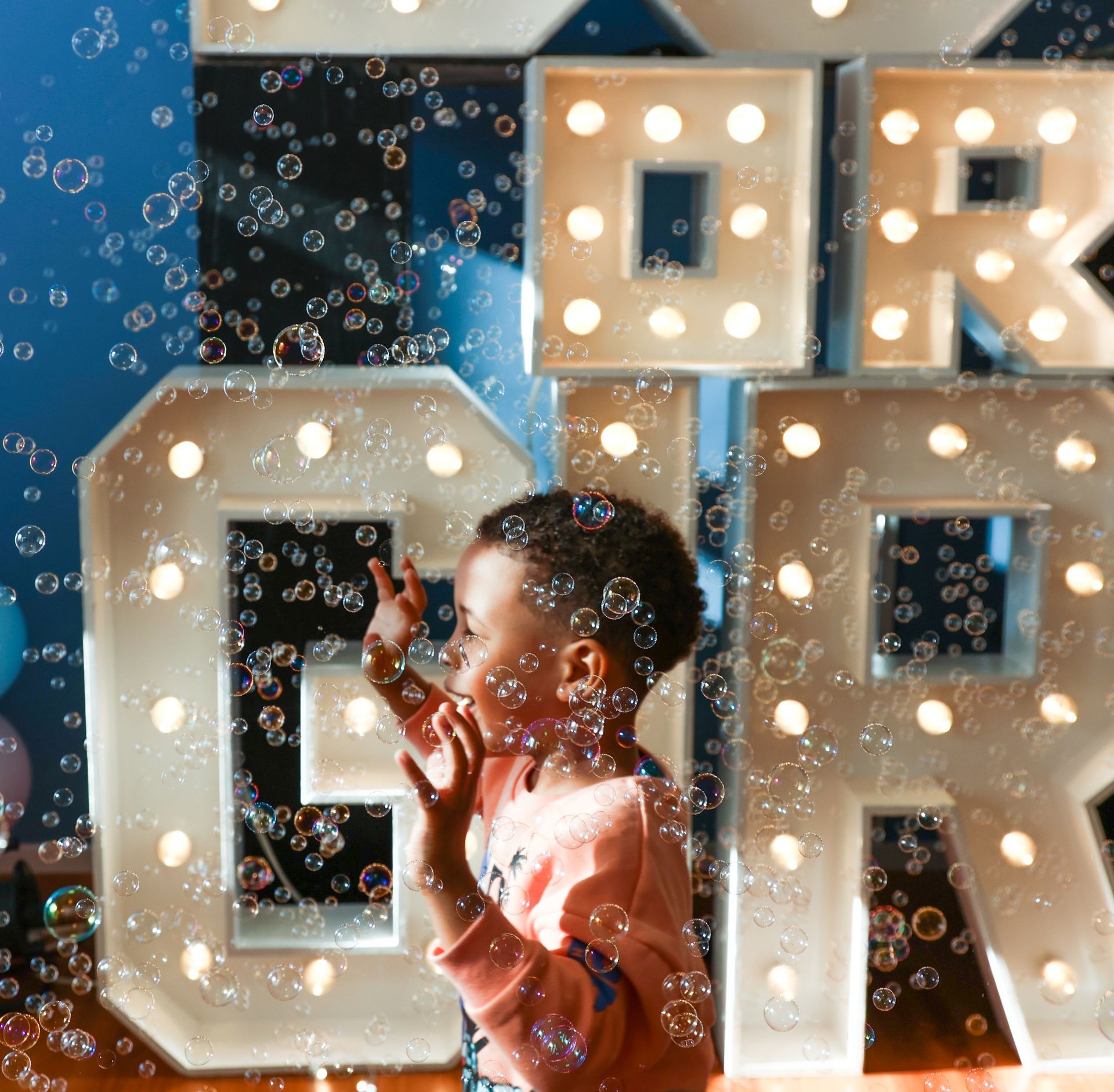 Kind dat naar bellen grijpt voor verlichte letters.